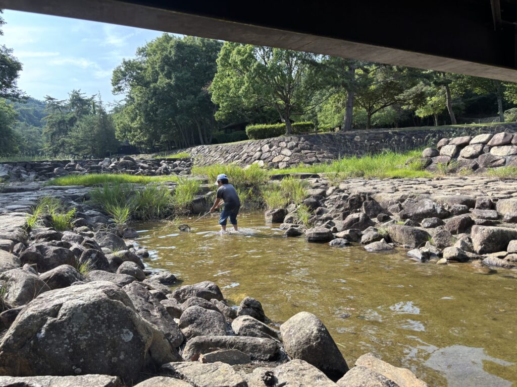 川の中で魚を取る8歳児