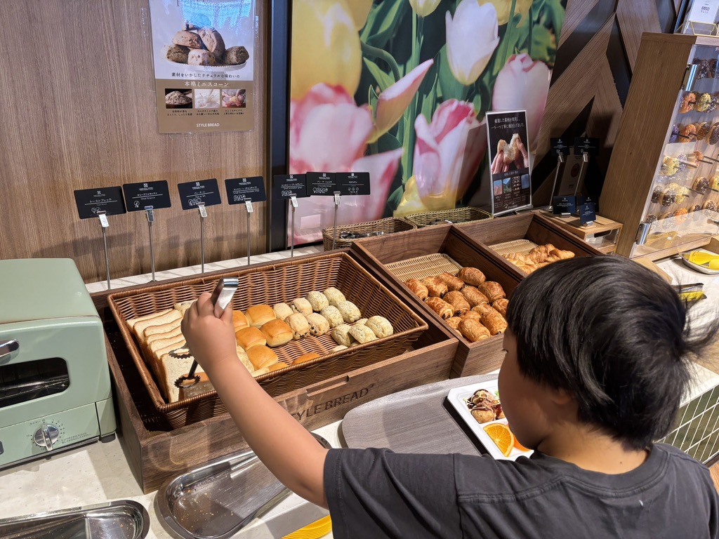 オリエンタルホテルユニバーサルシティでスタイルブレッドのパンを取る息子