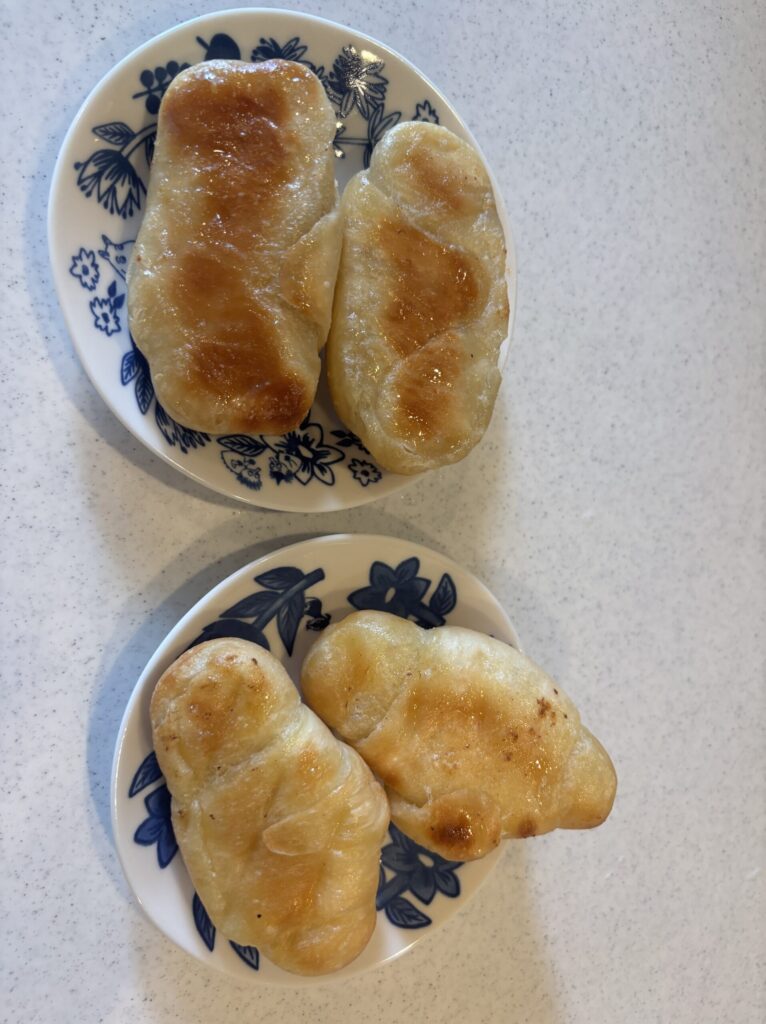 スタイルブレッド(STYLE BREAD)のメルティ塩バターパン(上)とおすすめ3位の塩パン(下)を裏返して並べたところ。底の焼き色の違いが分かる