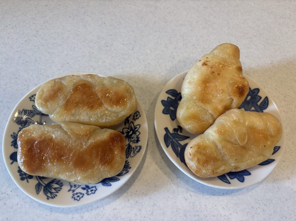 スタイルブレッド（STYLE BREAD）のメルティ塩バターパン（上）とおすすめ3位の塩パン（下）を裏返して並べたところ。底の焼き色の違いが分かる