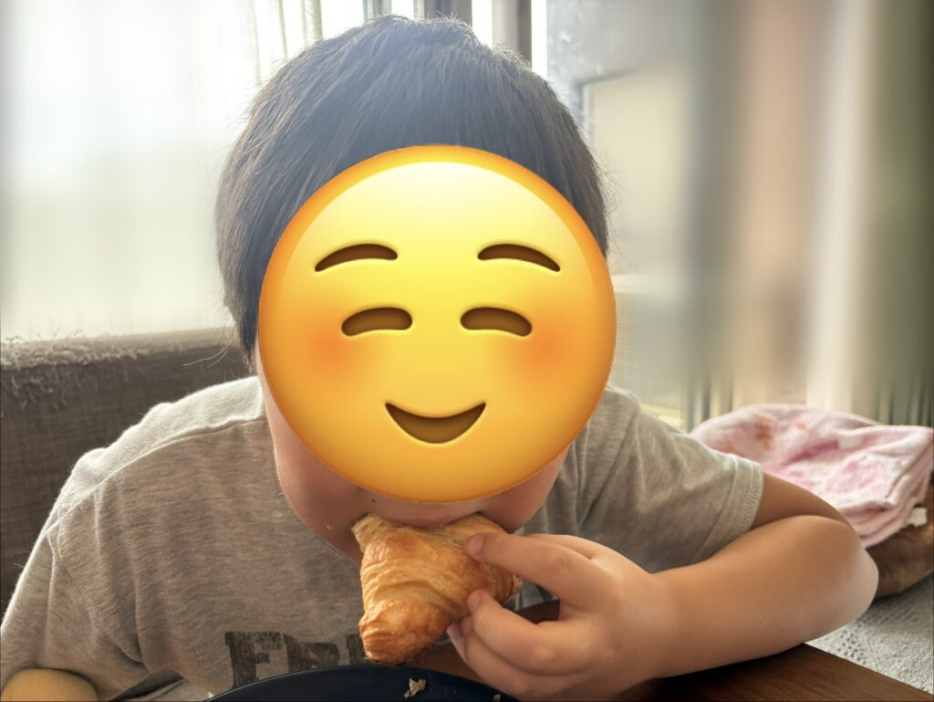 スタイルブレッド（STYLE BREAD）のはじめてパンセットに入っている至福のクロワッサンに息子がかぶりついているところ（顔はかくしています）