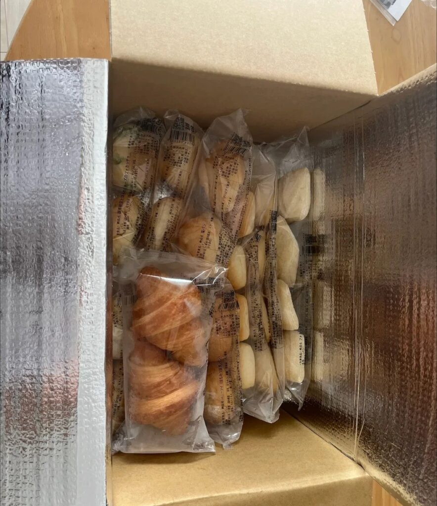 スタイルブレッド（STYLE BREAD）のはじめてパンセットの箱の中。保冷シートの内側にパンが袋のまま縦にぎっしり並んでいる