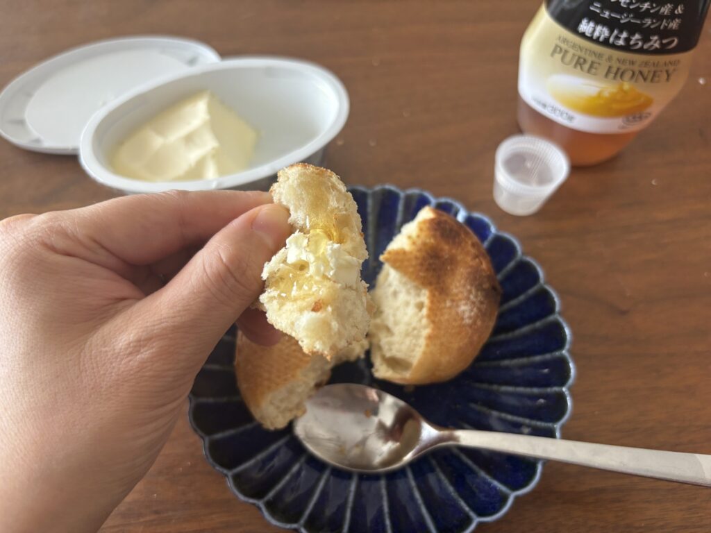 家で焼いたスタイルブレッド(STYLE BREAD)のパンを割って、バターとはちみつで食べているところ