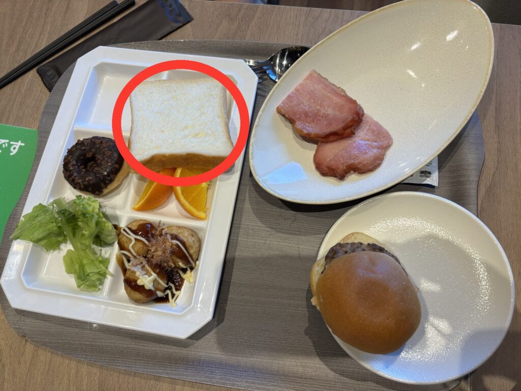 ホテルの朝食ビュッフェで取ったスタイルブレッド(STYLE BREAD)の食パンやロールパンをのせたトレー。個人でも買える食パンを赤丸で囲んでいる